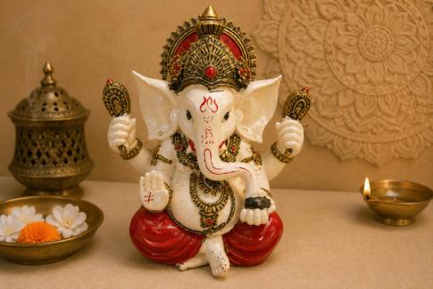 BUDAS Y GANESHAS | FIGURA GANESHA SENTADA COLOR BLANCO, JOYAS DORADAS Y ROPA ROJA 20 X 17 CM.